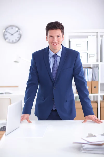 Fiducioso giovane uomo d'affari di successo appoggiato alle braccia sulla scrivania — Foto Stock