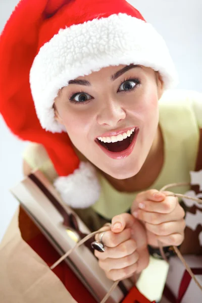 Ευτυχισμένος κορίτσι στο καπέλο santa κρατώντας μια τσάντα για ψώνια με το κιβώτιο δώρων — Φωτογραφία Αρχείου