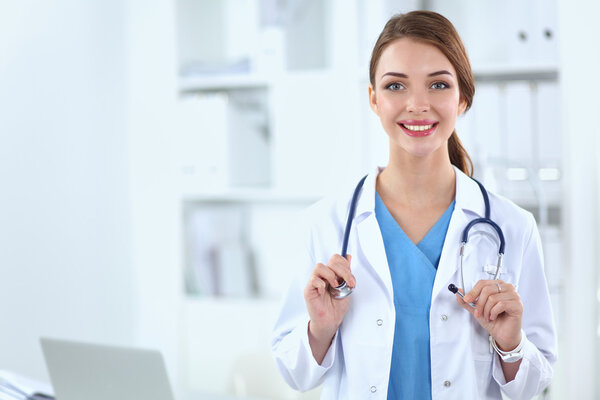 Portrait of happy successful young female doctor holding a stethoscope