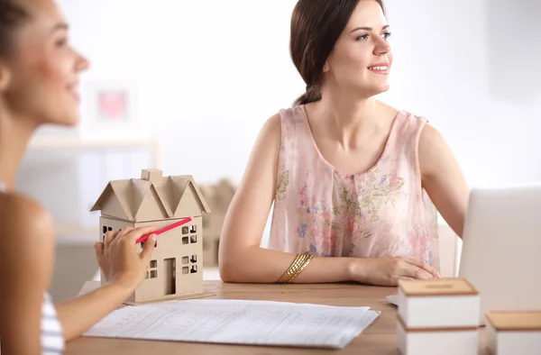 Portrait of female architect with blueprints at desk in office — Stock Photo, Image