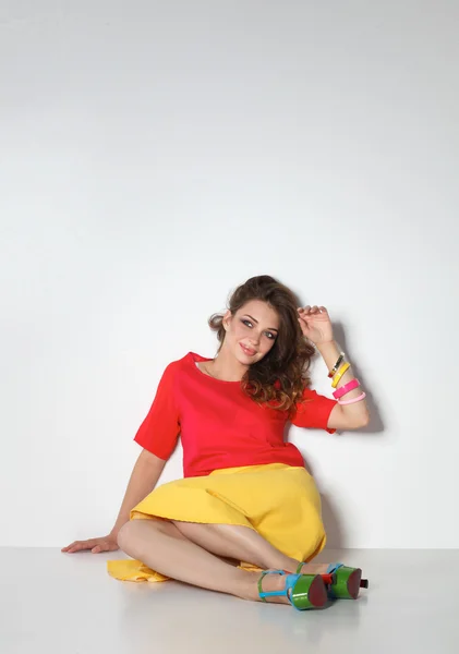 Young woman sitting on the floor, isolated in white background — Stock Photo, Image