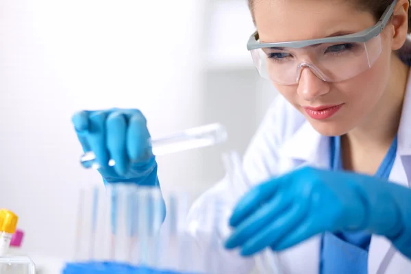 Woman researcher is surrounded by medical vials and flasks, isolated on white background — Stock Photo, Image