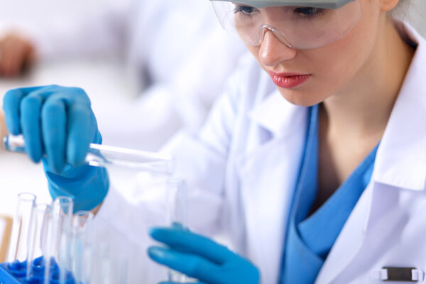 Woman researcher is surrounded by medical vials and flasks, isolated on white background