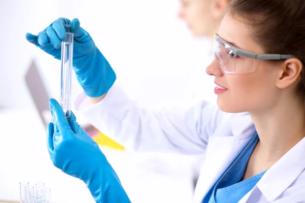 Woman researcher is surrounded by medical vials and flasks, isolated on white background — Stock Photo, Image