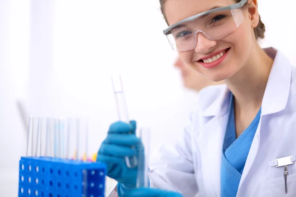 Woman researcher is surrounded by medical vials and flasks, isolated on white background — Stock Photo, Image