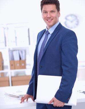 Ofiste masasının karşısında duran bir iş adamı ya da yönetici.