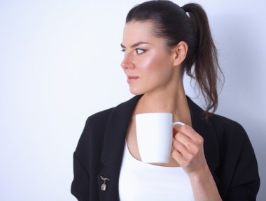 Beyaz arka plan üzerinde izole bir kupa tutan genç kadın