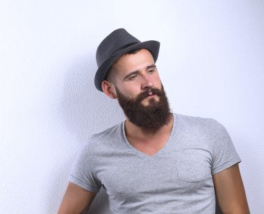 şapka ayakta, gri arka plan üzerinde izole yakışıklı sakallı adam portresi