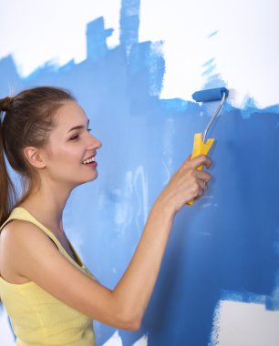 Duvar Boyama yaparken, merdiven üzerinde duran mutlu güzel genç kadın