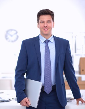 Ofiste masasının karşısında duran bir iş adamı ya da yönetici.