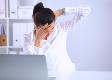 Ofiste masa başında oturan stresli iş kadını.