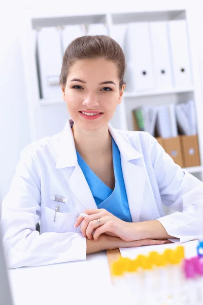 Woman researcher is surrounded by medical vials and flasks, isolated on white background — Stock Photo, Image