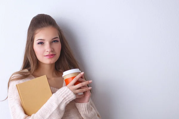 Portret van een jonge vrouw met een kopje thee of koffie, met boek — Stockfoto