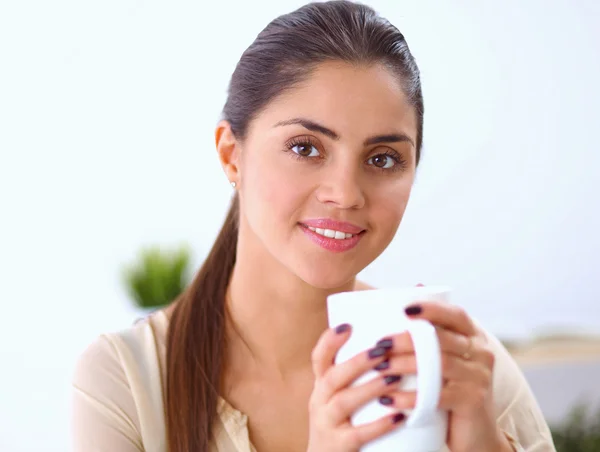 Mooie zakenvrouw genieten van koffie in helder kantoor — Stockfoto