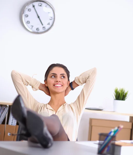 Mujer de negocios relajándose con las manos detrás de la cabeza y sentada en una silla de oficina — Foto de Stock