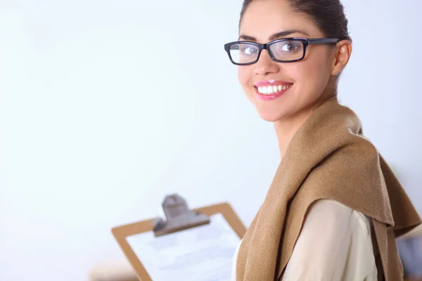 Attractive young businesswoman standing near desk with folder in the office — Stock Photo, Image