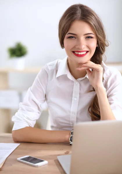 Attraktive Geschäftsfrau sitzt auf Schreibtisch im Büro — Stockfoto