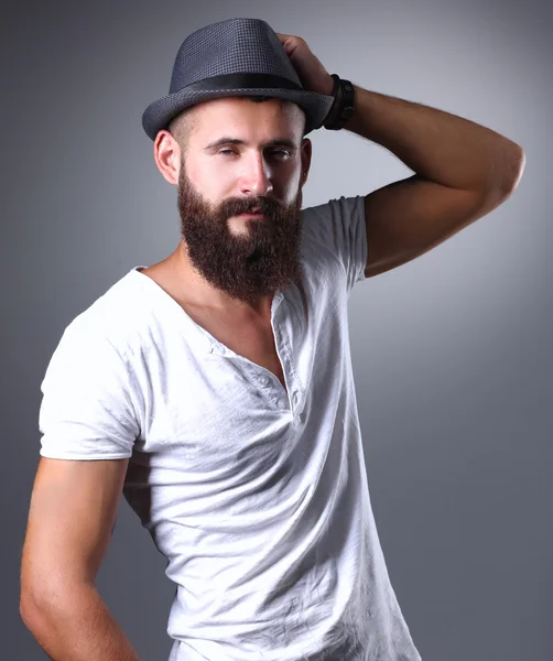 Retrato de hombre barbudo guapo con sombrero de pie, aislado sobre fondo gris —  Fotos de Stock