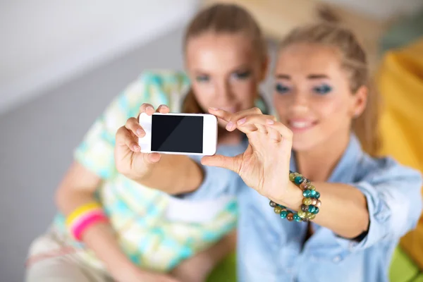 Dos chicas tomando fotos por teléfono en casa —  Fotos de Stock