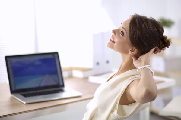 Mujer de negocios relajándose con las manos detrás de la cabeza y sentada en una silla de oficina — Foto de Stock