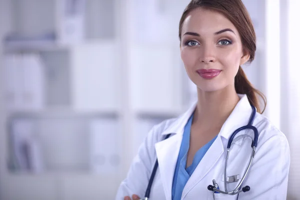 Retrato de una joven doctora con una bata blanca de pie en el hospital —  Fotos de Stock