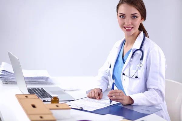 Doctora sentada en el escritorio y trabajando en un portátil en el hospital — Foto de Stock