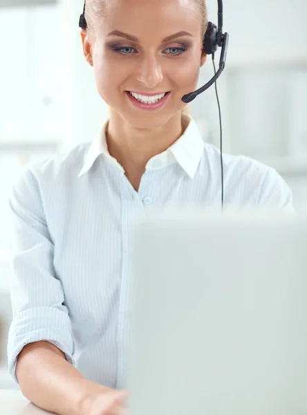 Retrato de una hermosa mujer de negocios trabajando en su escritorio con auriculares y laptop — Foto de Stock