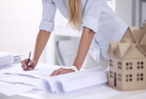 Retrato de una arquitecta con planos en el escritorio en la oficina — Foto de Stock