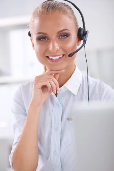 Retrato de una hermosa mujer de negocios trabajando en su escritorio con auriculares y laptop — Foto de Stock