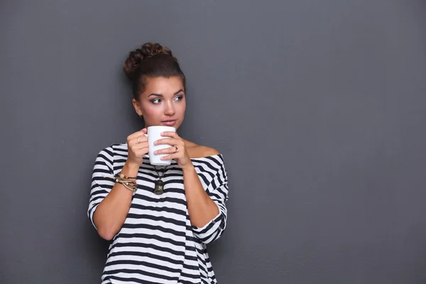 Portret van een jonge vrouw met een kopje thee of koffie — Stockfoto