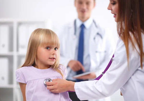 Female doctor examining child with stethoscope at surgery — Stock Photo, Image