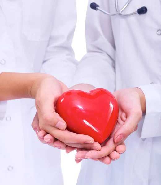 Two woman doctor holding a red heart, isolated on white background — Stock Photo, Image