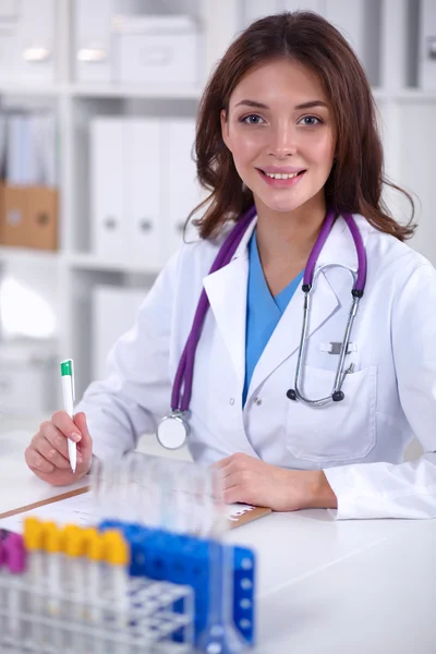 Femme chercheuse entourée de flacons et flacons médicaux, isolée sur fond blanc — Photo
