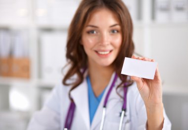 Kadın doktor elinde boş bir kart tutuyor, beyaz arka planda izole edilmiş.