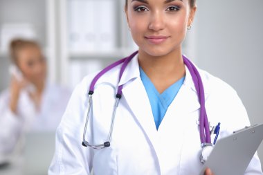 Hastanede üniformalı, gülümseyen bir kadın doktor.
