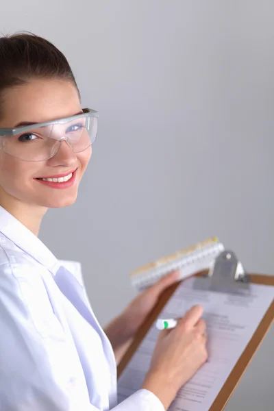 Lächelnde Ärztin mit Ordner in Uniform steht im Krankenhaus — Stockfoto