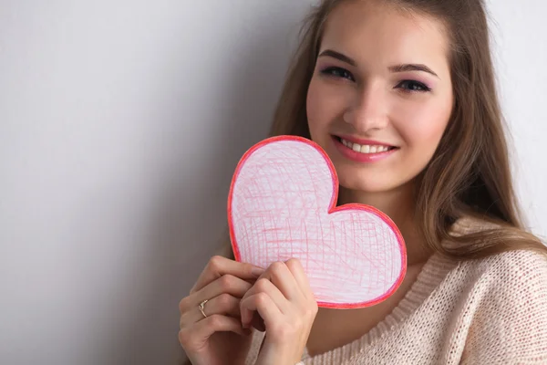 Portrait of beautiful happy woman holding a symbol heart. — Stock Photo, Image