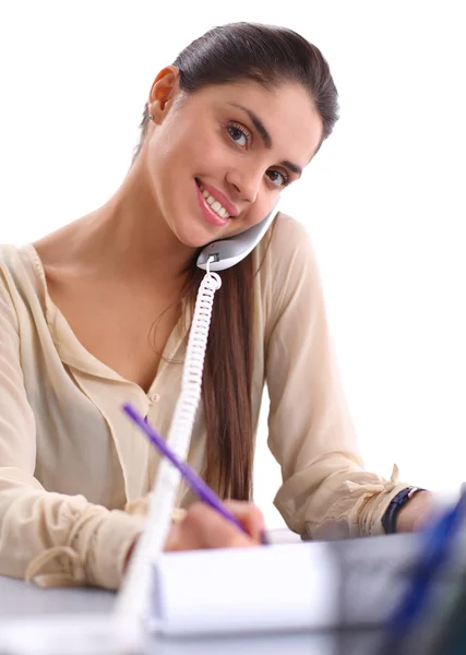 Jovem empresária sentada na mesa e conversando ao telefone — Fotografia de Stock