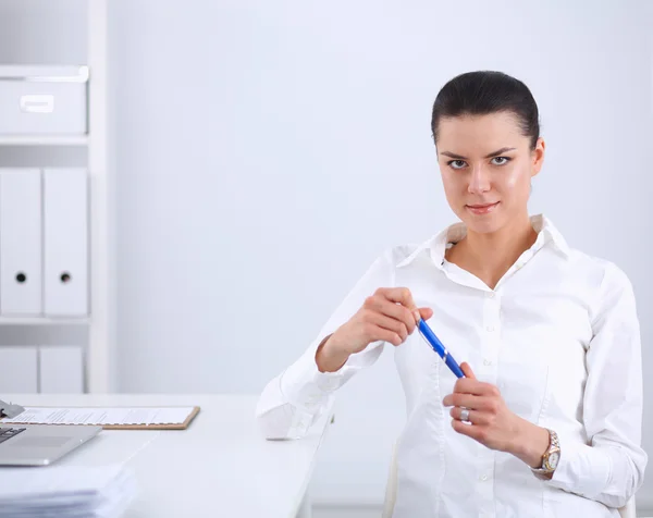 Jolie femme d'affaires assise sur un bureau avec ordinateur portable dans le bureau — Photo