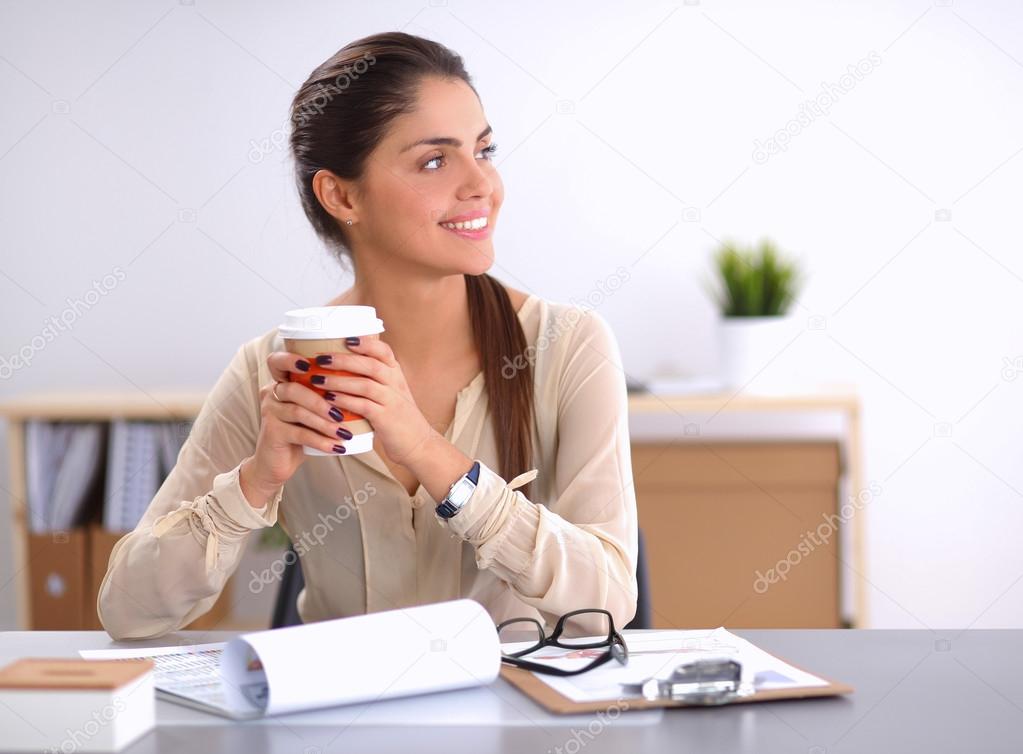 Beautiful  businesswoman enjoying coffee in bright office