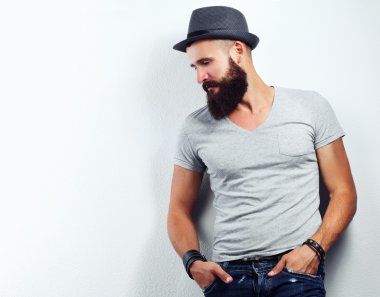 şapka ayakta, gri arka plan üzerinde izole yakışıklı sakallı adam portresi