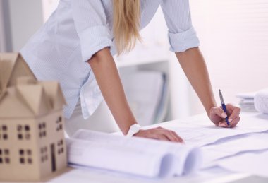 Ofisinde planları olan kadın mimarın portresi.