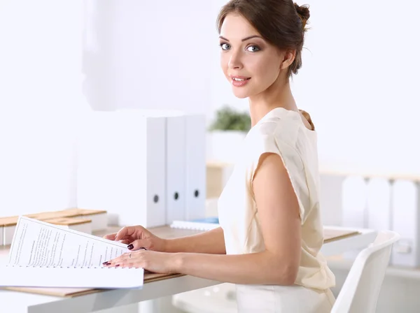 Retrato de uma mulher de negócios sentada na mesa com papel — Fotografia de Stock