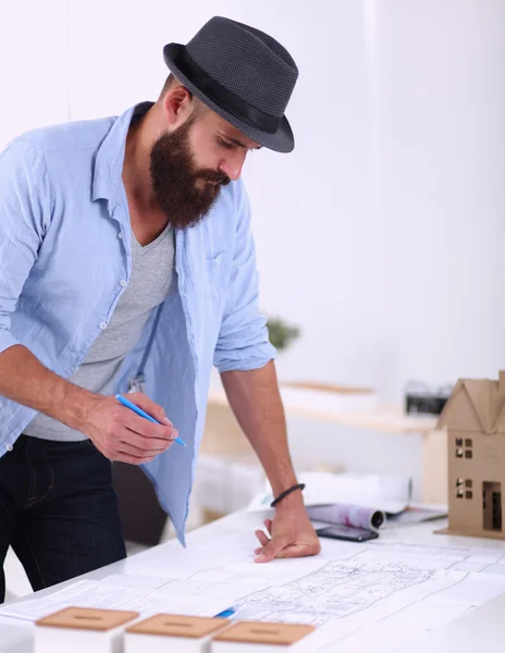 Retrato de diseñador masculino en sombrero con planos en el escritorio —  Fotos de Stock