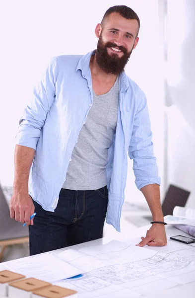 Portret van mannelijke architect met blauwdrukken op balie in kantoor — Stockfoto