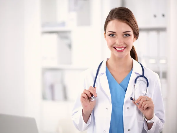 Portrait of young woman doctor with white coat standing in hospital — Stock Photo, Image