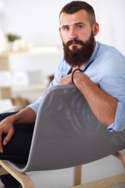 Genç işadamı koltukta oturuyor.