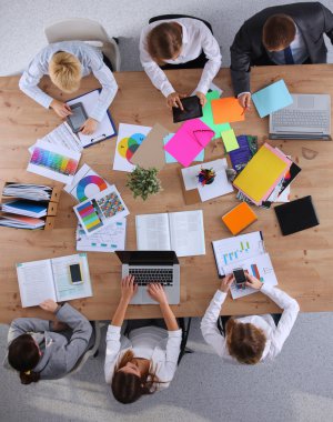 İş adamları iş toplantısında, ofiste oturup tartışıyorlar.