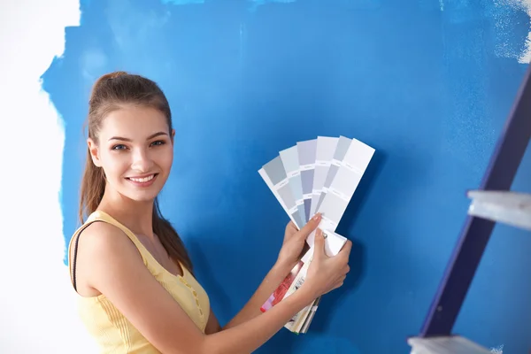 Giovane bella donna in possesso di tavolozza dei colori, in piedi vicino alla parete . — Foto Stock