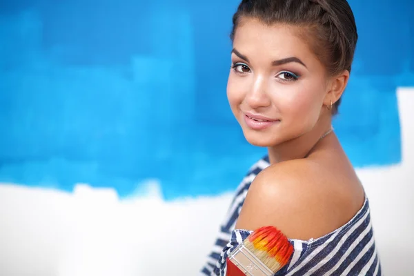 Portrait of female painter sitting on floor near wall after painting. — Stock Photo, Image